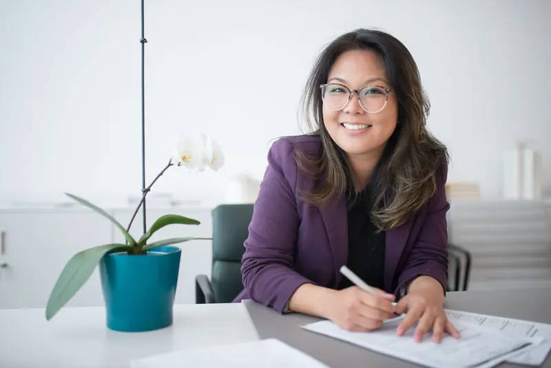 Smiling professional writing notes at her desk