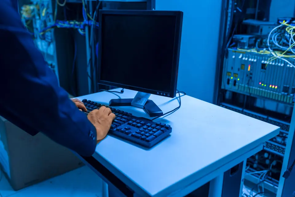 Technician working at a console inside a server room