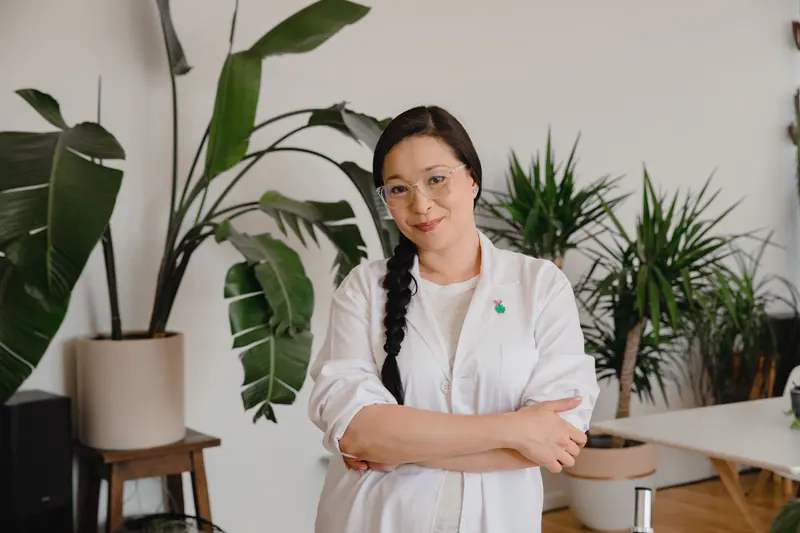 Confident founder standing in her bright, plant-filled studio